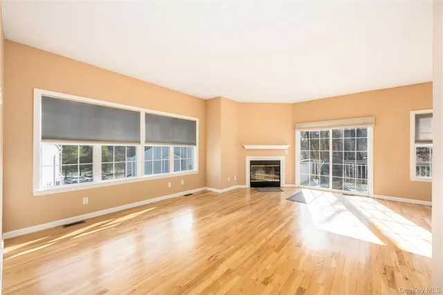 a view of empty room with a fireplace and wooden floor