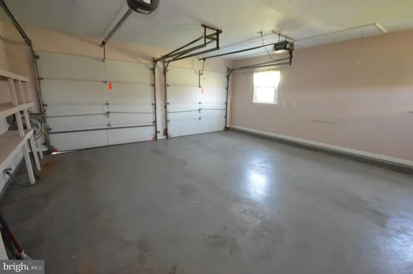 en empty room with windows and ceiling fan