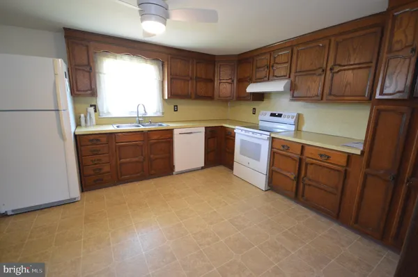a kitchen with stainless steel appliances granite countertop a refrigerator a sink dishwasher a stove top oven a sink and dishwasher