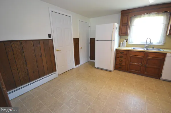 a view of a kitchen with a refrigerator and cabinet
