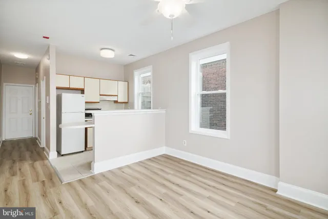 a view of a kitchen with wooden floor and a window