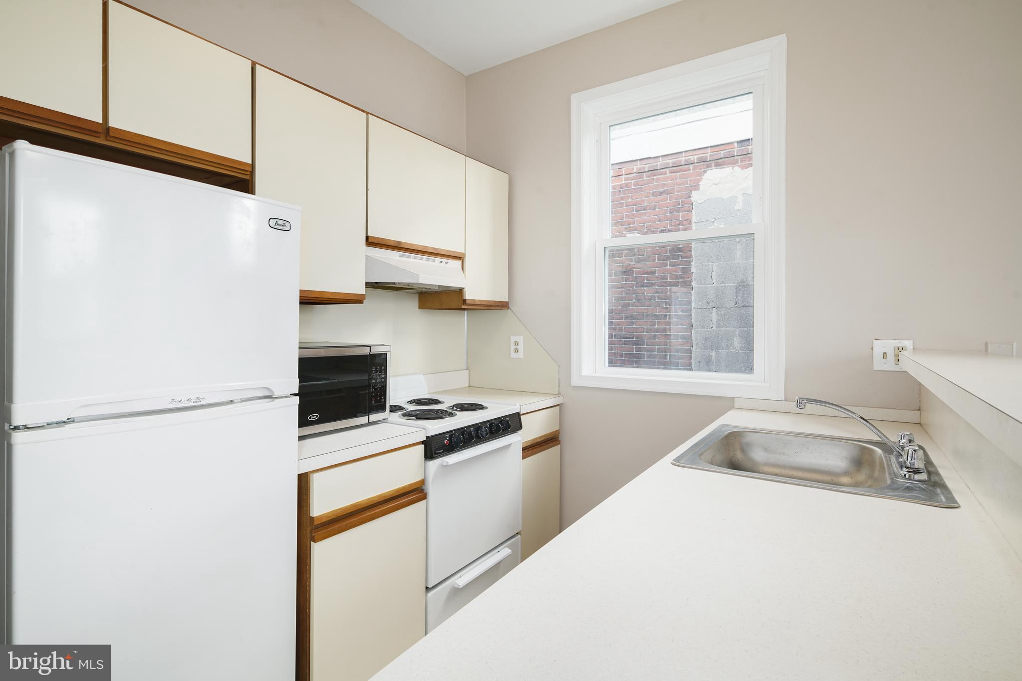 2338 South Broad Street Philadelphia, PA 19145 - Photo 4 of 7 a kitchen with a sink a stove and a refrigerator