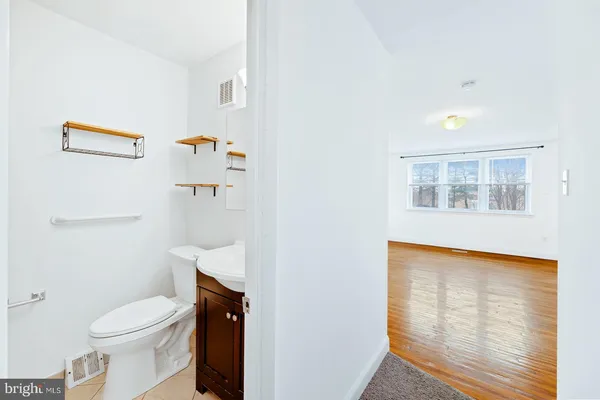 a white toilet sitting next to a bathroom sink and vanity