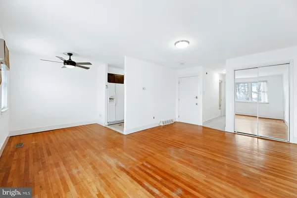 a view of empty room with wooden floor and windows