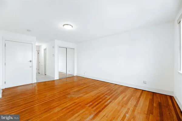 a view of empty room with wooden floor