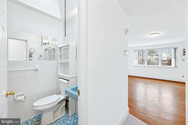 a white toilet sitting next to a bathroom sink and a mirror