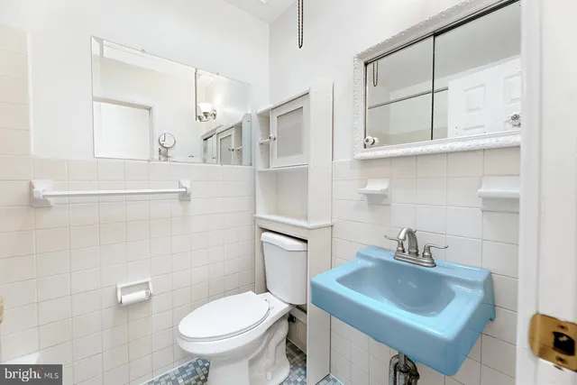 a bathroom with a sink toilet and a mirror