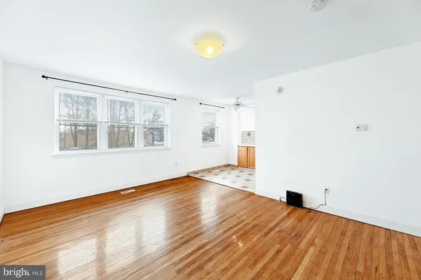 a view of empty room with wooden floor and window