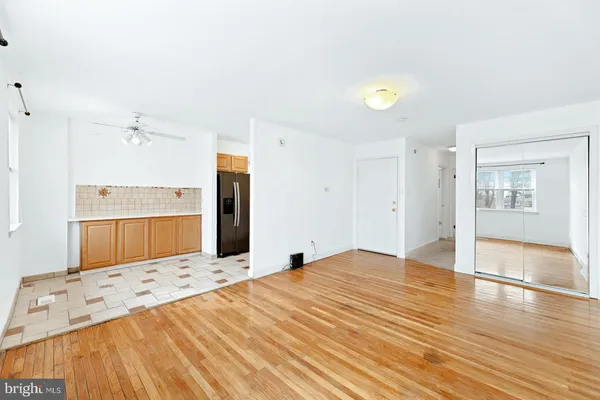 a view of a kitchen with kitchen island a sink wooden floor and a refrigerator