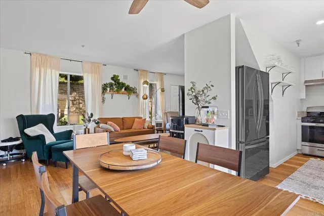 a living room with furniture and a refrigerator