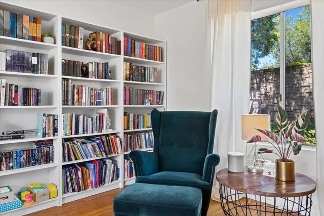 a view of a workspace with bookshelf and a window