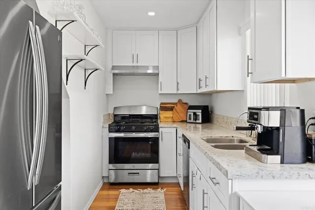 a kitchen with a stove a refrigerator and a sink