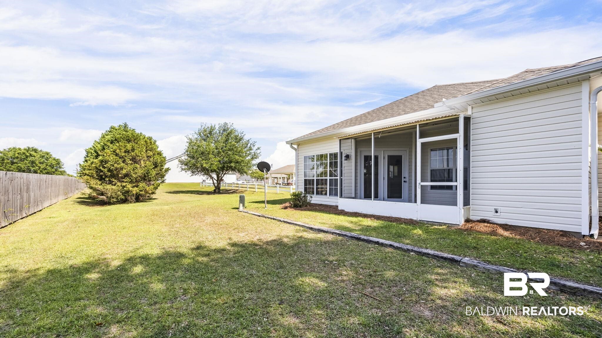 2651 South Juniper Street, Unit 705 Foley, AL 36535 - Photo 24 of 37 Expansive green lawn with mature trees and a privacy fence