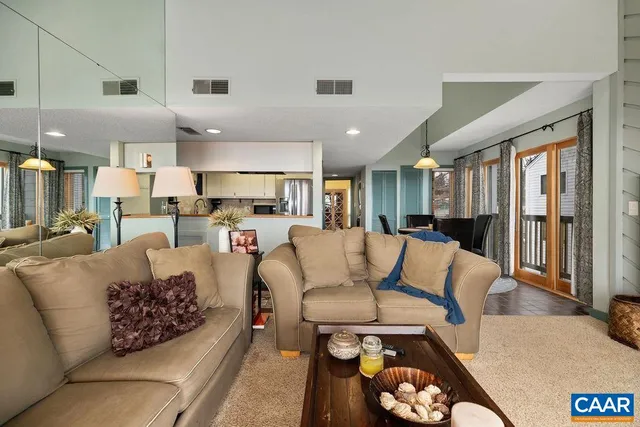 a living room with furniture kitchen view and a large window