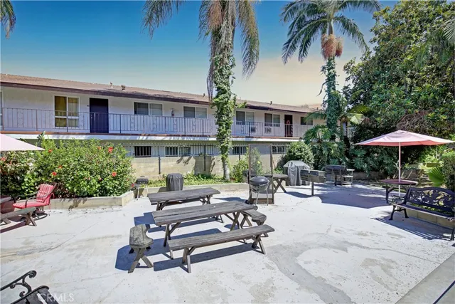 a view of a patio with a table and chairs under an umbrella