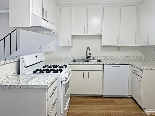 a kitchen with granite countertop a sink stove and cabinets