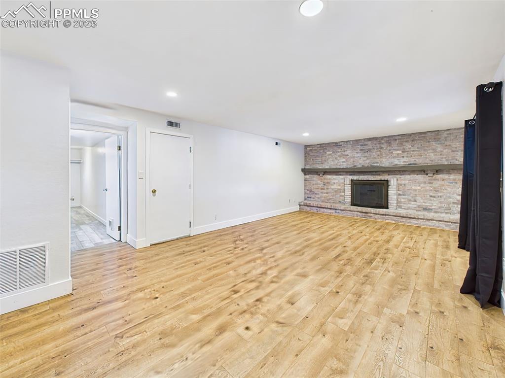 5040 Escapardo Way Colorado Springs, CO 80917 - Photo 18 of 50 a view of empty room with wooden floor and fireplace