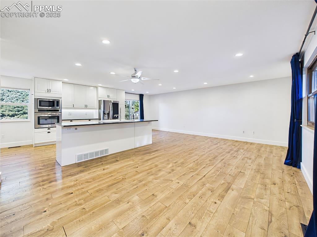 5040 Escapardo Way Colorado Springs, CO 80917 - Photo 3 of 50 a large kitchen with stainless steel appliances kitchen island a large counter top and a wooden floors