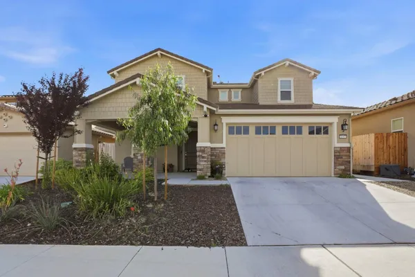 a front view of a house with a garden