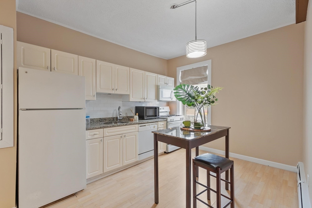 793 Main Street, Unit 1 Malden, MA 02148 - Photo 1 of 8 a kitchen with stainless steel appliances granite countertop a refrigerator a sink a stove and white cabinets