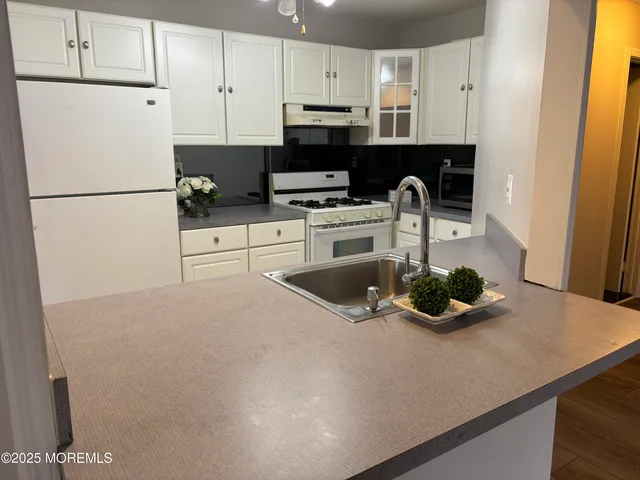 a kitchen with a refrigerator and a stove top oven