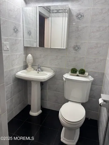 a bathroom with a toilet a sink and mirror