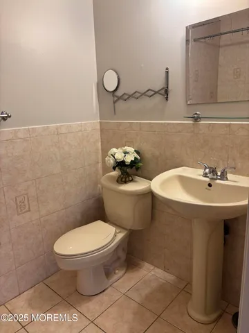 a bathroom with a toilet a sink and mirror