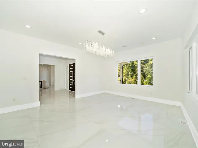 a kitchen with stainless steel appliances kitchen island granite countertop white cabinets and window