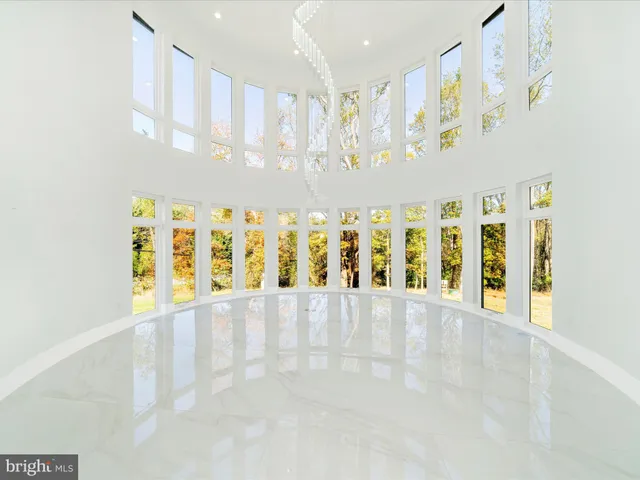 a spacious bedroom with a large window and chandelier