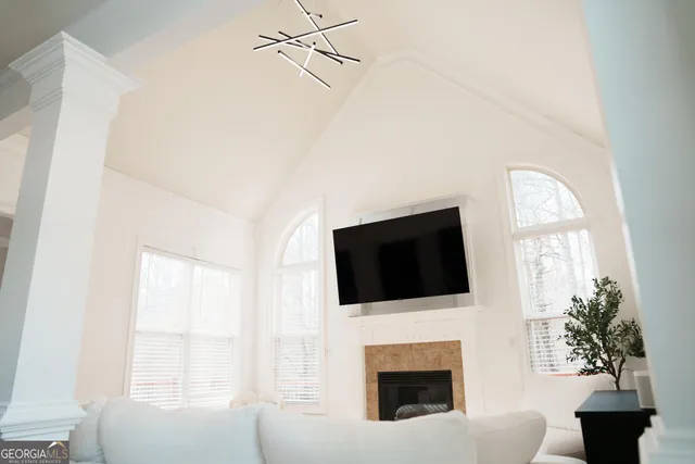 a living room with a fireplace a flat screen tv and a window