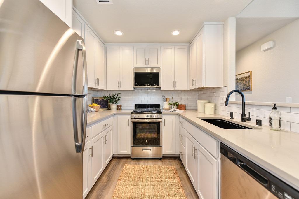 2660 Commons Place Auburn, CA 95603 - Photo 19 of 55 a kitchen with white cabinets and white appliances
