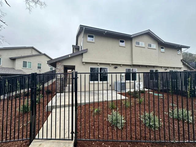 a view of a house with backyard and trees