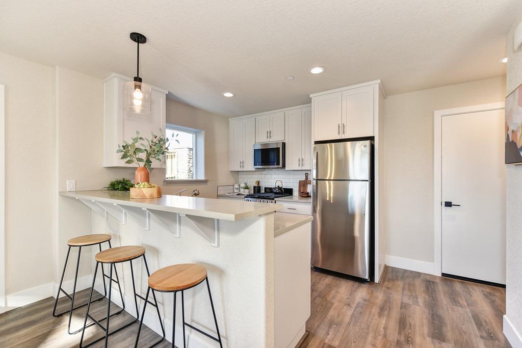 2660 Commons Place Auburn, CA 95603 - Photo 41 of 55 a kitchen with stainless steel appliances granite countertop a refrigerator a stove a sink dishwasher and a refrigerator with wooden floor