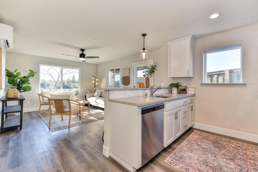 2660 Commons Place Auburn, CA 95603 - Photo 43 of 55 a kitchen with stainless steel appliances granite countertop a stove a sink dishwasher and a dining table with wooden floor