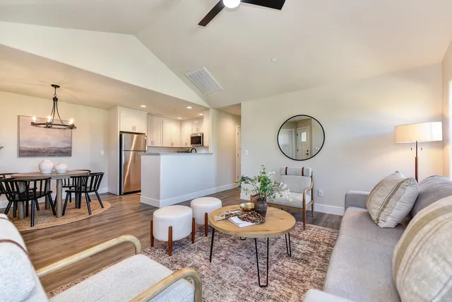 a living room with furniture a window and a large mirror
