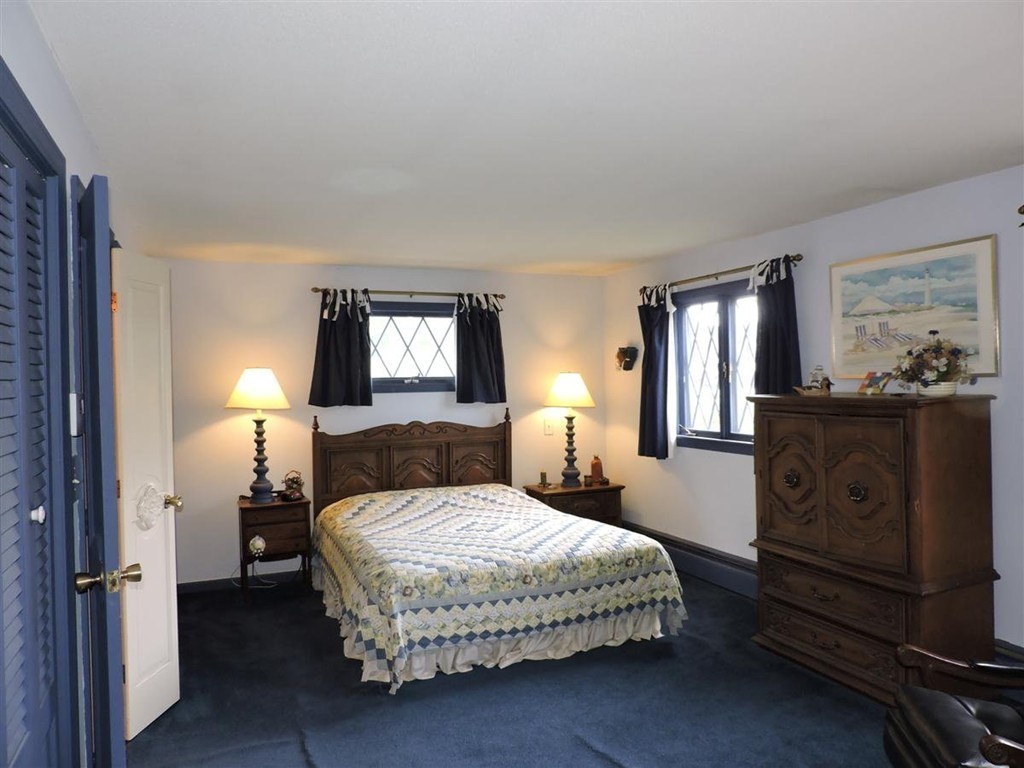 46 Point Pleasant Road Webster, MA 01570 - Photo 19 of 30 a bedroom with a bed a mirror on dresser and a window