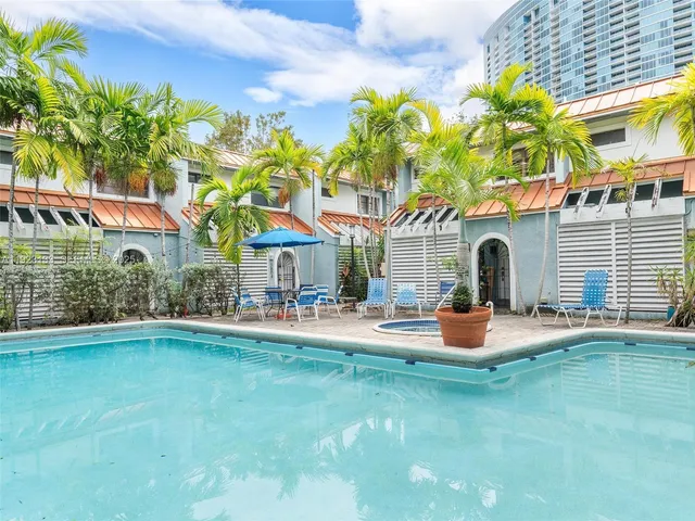 a front view of a house with swimming pool and chairs