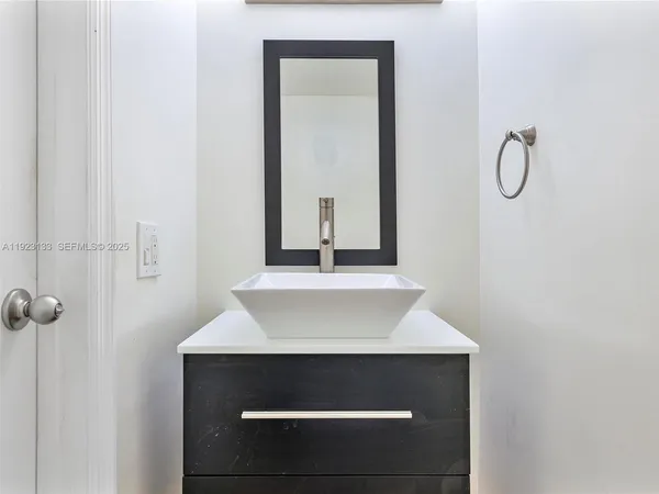 a kitchen with granite countertop white cabinets and a sink