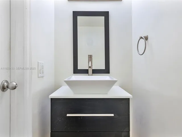 a kitchen with granite countertop white cabinets and a sink
