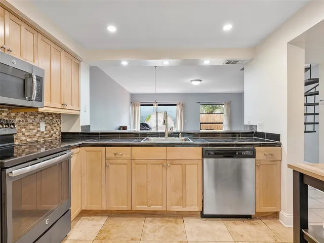 a kitchen with stainless steel appliances granite countertop a refrigerator sink and cabinets