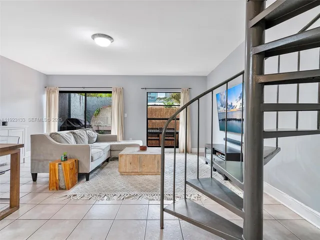 a patio with table and chairs and potted plants