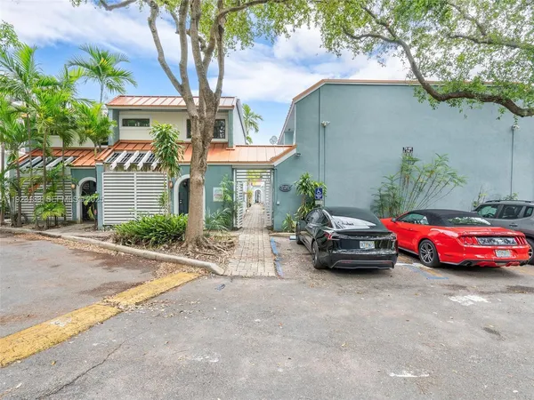 a front view of a house with cars parked