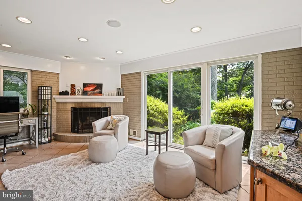 a living room with furniture a fireplace and a floor to ceiling window