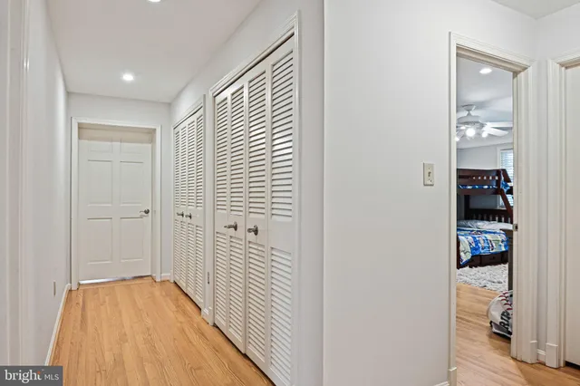 a view of a hallway with wooden floor and closet