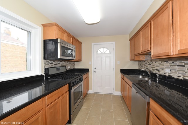 1915 Herbert Avenue Berkeley, IL 60163 - Photo 3 of 10 a kitchen with stainless steel appliances granite countertop a sink stove and cabinets