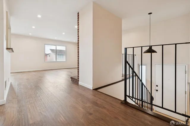 an empty room with wooden floor and fireplace