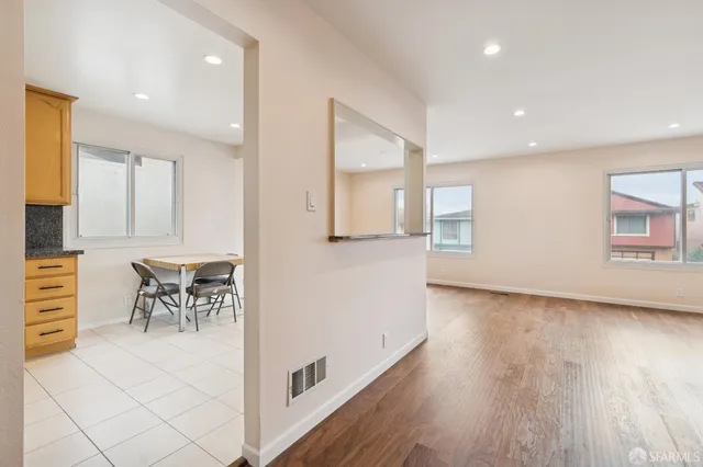 a view of an empty room with a window and wooden floor