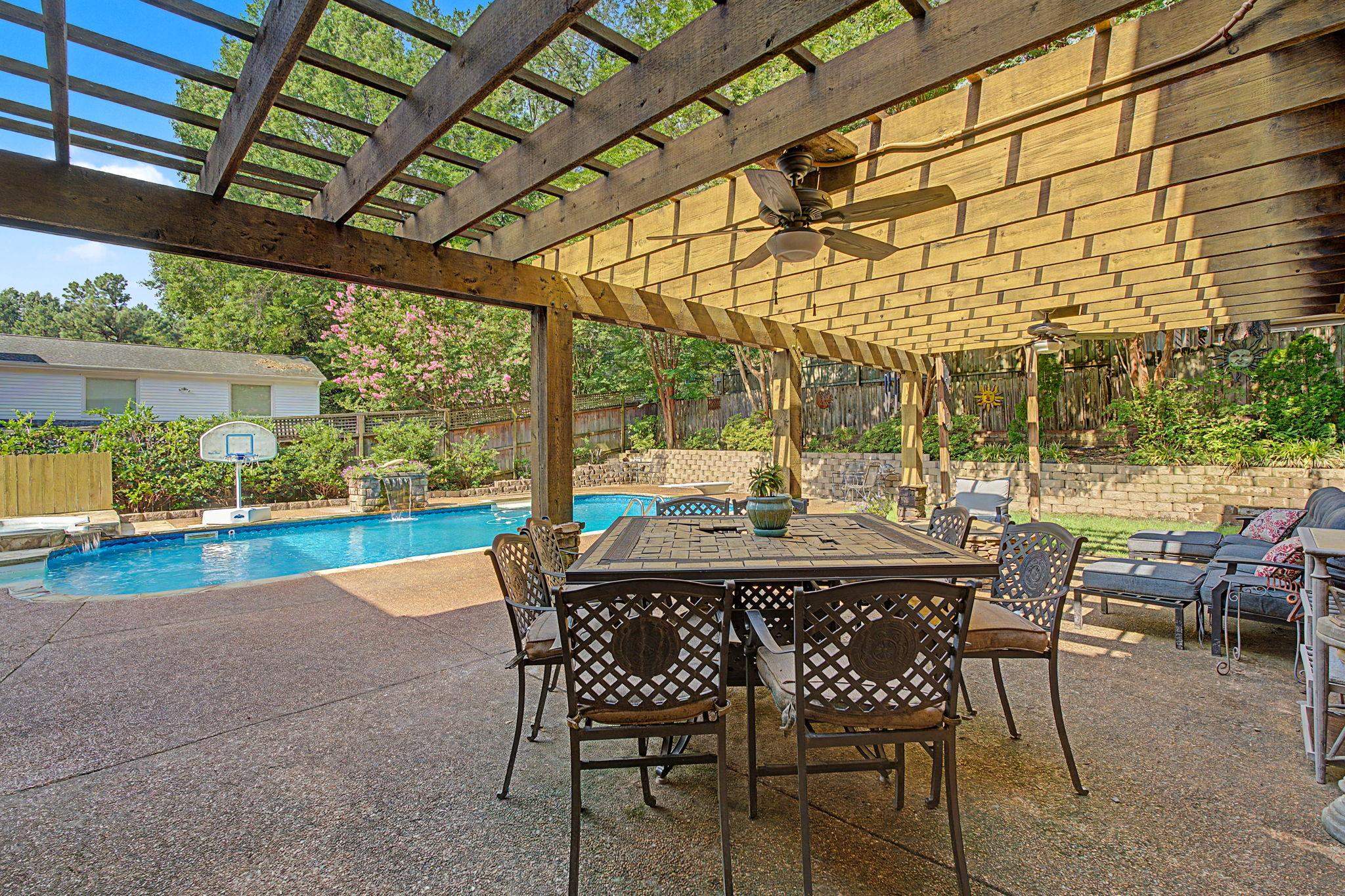1929 Miller Farms Road Germantown, TN 38138 - Photo 34 of 40 Expansive outdoor living area featuring a large wooden pergola with integrated ceiling fans, a substantial concrete patio, and a built-in swimming pool