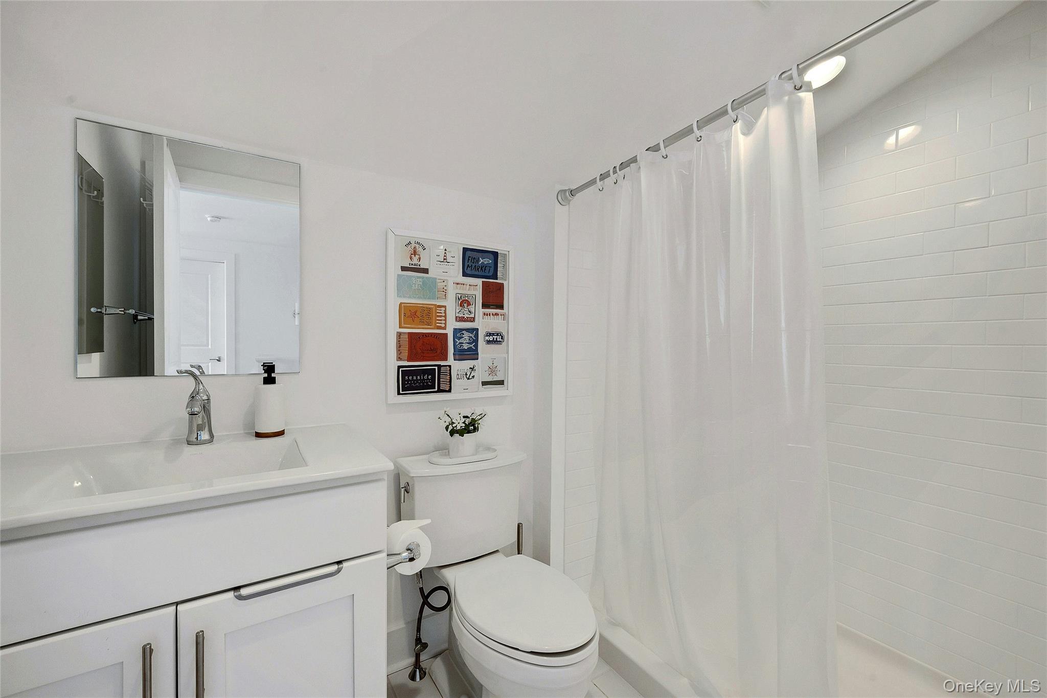 39 Island Point Bronx, NY 10464 - Photo 24 of 37 a bathroom with a sink a toilet and shower curtain