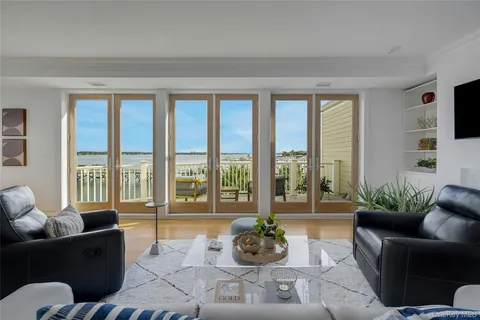 a living room with furniture and floor to ceiling windows